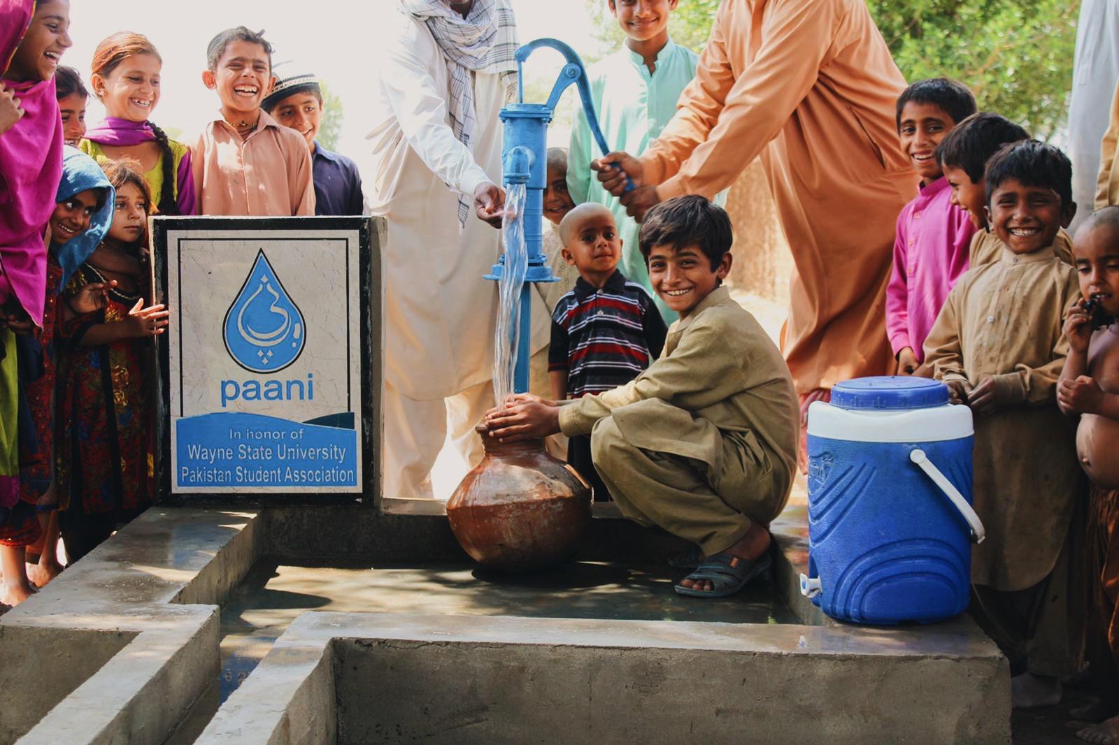 A boy drinking clean water from a well